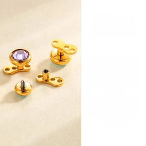 Detailed macro view of gold G23 titanium dermal anchor set with purple zircon stone