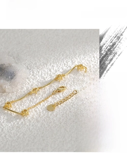 Close-up of gold-plated brass bracelet with prong-set cubic zirconia and lobster clasp