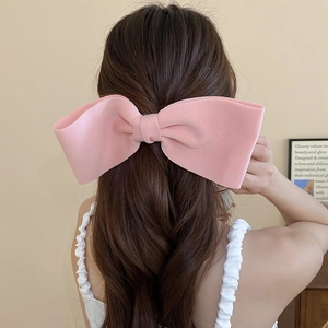 Sweet pink oversized fabric bow hair clip shown on model for elegant hairstyling