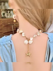 Detail of seashell and starfish pendant necklace set on female neck for beach vacation style