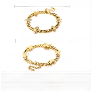 Detail view of gold stainless steel bracelets with pineapple and butterfly pendants