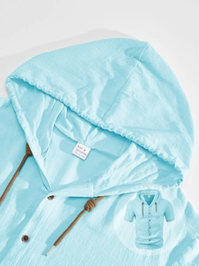 Close-up of light blue linen shirt texture with woven drawstrings and button detail