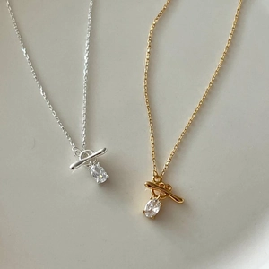 Detail of 925 silver necklaces in gold and silver with T-bar toggle and zircon stone