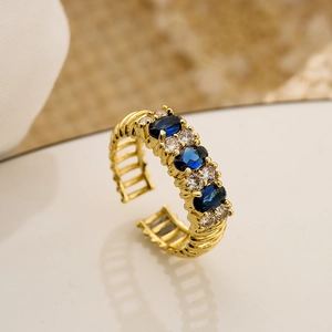 18K gold plated open ring featuring blue oval zircons and hollow striped band