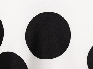 Primer plano de la textura de tela con lunares blancos y negros y detalle tejido fino