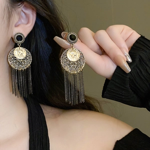 Détails des boucles d'oreilles dorées avec camée noir et longues franges métalliques