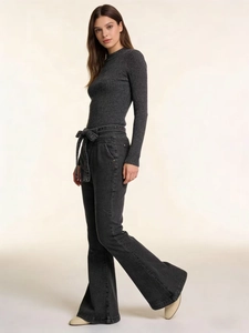 Detail of high-waist lace-up flare jeans paired with a slim-fit knit long sleeve top