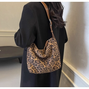 Close-up of leopard print tote bag with brown leather strap in a lifestyle setting