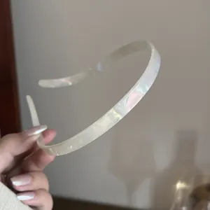 Detailed macro view of cream pearlescent acetate headband with soft iridescent finish