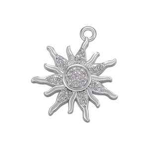 Macro shot of silver sun pendant featuring micro-pave zircons on a white background