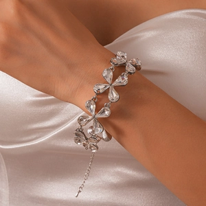 Detail of crystal flower bracelet on wrist with elegant white satin background