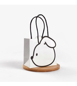 Close-up of minimalist white paper gift bag with a black animal line drawing and handle