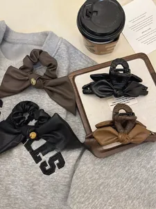 Vista piatta di mollette e elastici per capelli in pelle vintage con eleganti tocchi dorati