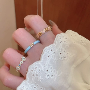 Close-up of elegant floral and star rings with blue enamel and sparkling rhinestones
