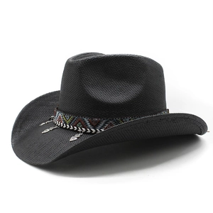 Détail d'un chapeau de cowboy noir tressé avec ruban ethnique et pendentif coeur argent