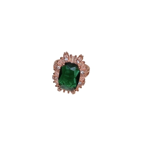Vintage emerald cut green gemstone ring with halo diamonds on rose gold band