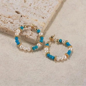 Detailed macro view of bohemian hoop earrings with white pearls and blue turquoise beads