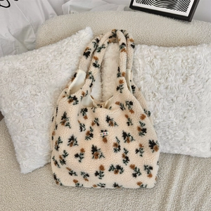 Close-up of fluffy floral plush tote bag with embroidered letters and soft lining