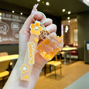 Close-up of Sakura themed keychain with orange dried flowers and silicone wrist strap