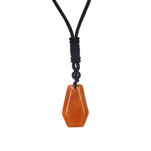 Detail of translucent orange crystal necklace with hexagonal cut and black braided cord