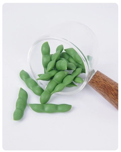 Macro detail of miniature green PVC pea pods with realistic texture in a glass cup