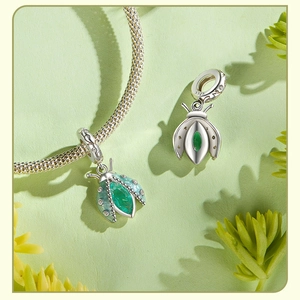 Vue macro des charmes coccinelle en argent S925 avec cristaux verts et pierres fines