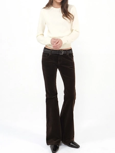 Detail view of dark brown corduroy flared pants paired with a black leather belt