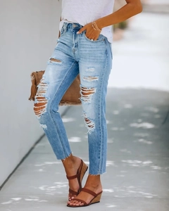 Nahaufnahme der Distressed-Details und des offenen Saums der hellblauen Damenjeans