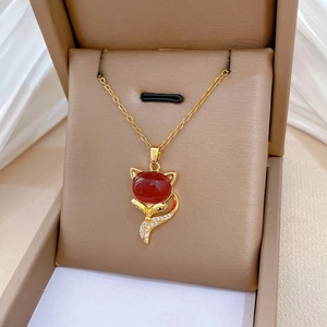 Detailed view of fox pendant with red gemstone and white zircons in a jewelry box
