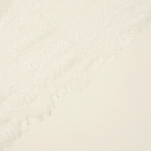 Detailed white lace eyelash veil with intricate floral patterns and raw edge design