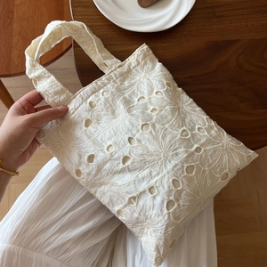 Detailed embroidery on white lace tote bag with floral patterns in French retro style