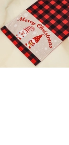 Detail of red and black buffalo plaid Christmas table runner with festive gnome print