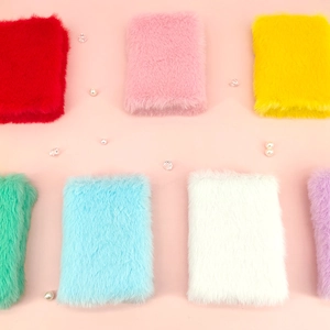 Mini A7 pluche pocket notitieboekjes in diverse snoepkleuren op decoratieve achtergrond