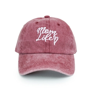 Detailed view of Mom Life white embroidery on washed pink cotton baseball cap fabric