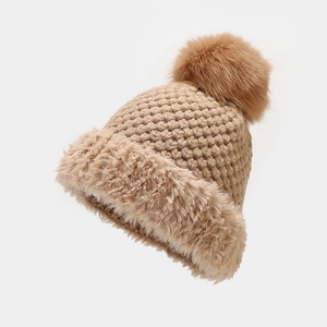 Detail of camel chunky knit winter hat featuring twin faux fur pom poms and soft trim