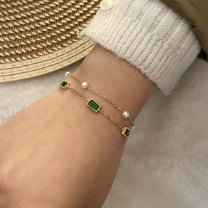 Double-layer gold bracelet with emerald-cut green gems and small white pearls