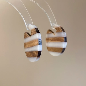 Detail of vintage wooden and resin earrings with striped texture on acrylic stands