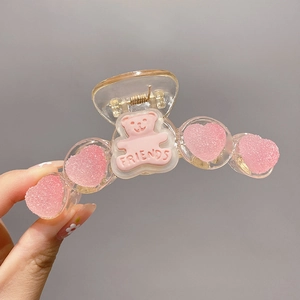 Detail of pink gummy bear hair claw clip with heart accents and Friends engraving