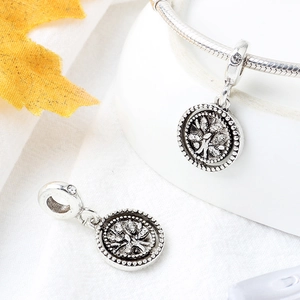 Macro detail of silver tree of life pendants and clover charm on DIY bracelet accessory