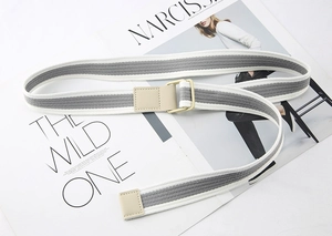 Detail of grey and white striped canvas belt with beige faux leather trim and metal buckle