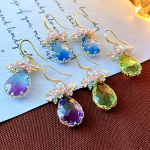 Detailed macro shot of pear-cut gemstone drop earrings with floral zircon accents