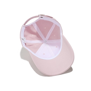 Detail of pink cotton baseball cap interior showing white support strip and metal buckle