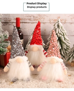 Close-up of three sequined Christmas gnomes with glowing noses on artificial snow