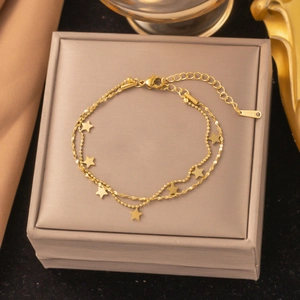 Double-layered stainless steel star necklace with gold finish on jewelry box