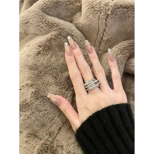 Silver multi-layer crisscross ring with zircon pavé, worn on a model's index finger