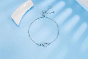 Detail of silver heart and infinity charm bracelet with adjustable slider and cubic zirconia