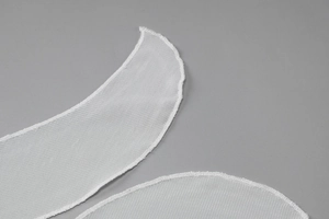 Gros plan sur le tissu en dentelle mesh blanche avec coutures délicates pour robe