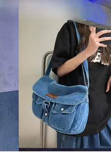 Sac messager en denim bleu avec rabat et détails de patch en cuir marron