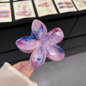 Détail d'une pince à cheveux fleur translucide avec texture effet marbre