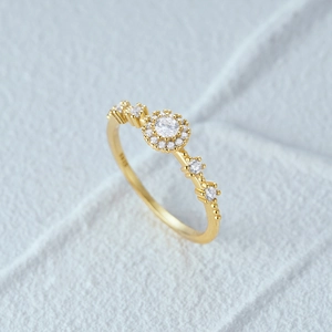 Macro shot of S925 sterling silver gold plated halo ring with round diamond and micro pave